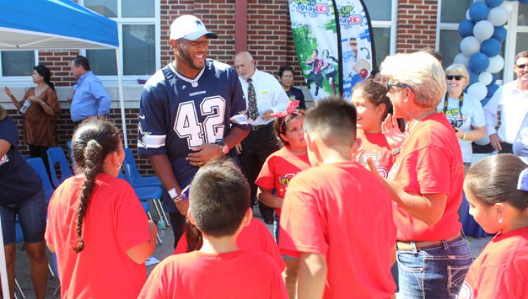 Dallas cowboy speaking with a group of students