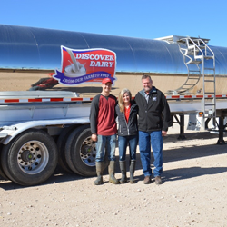 family in front of a tanker of milk