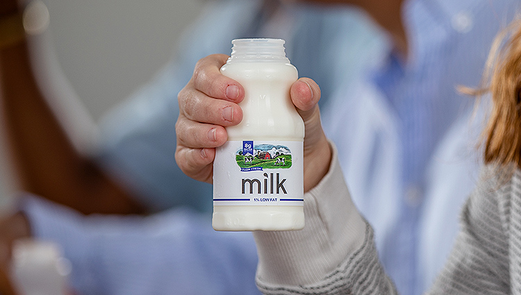 Person holding a bottle of milk