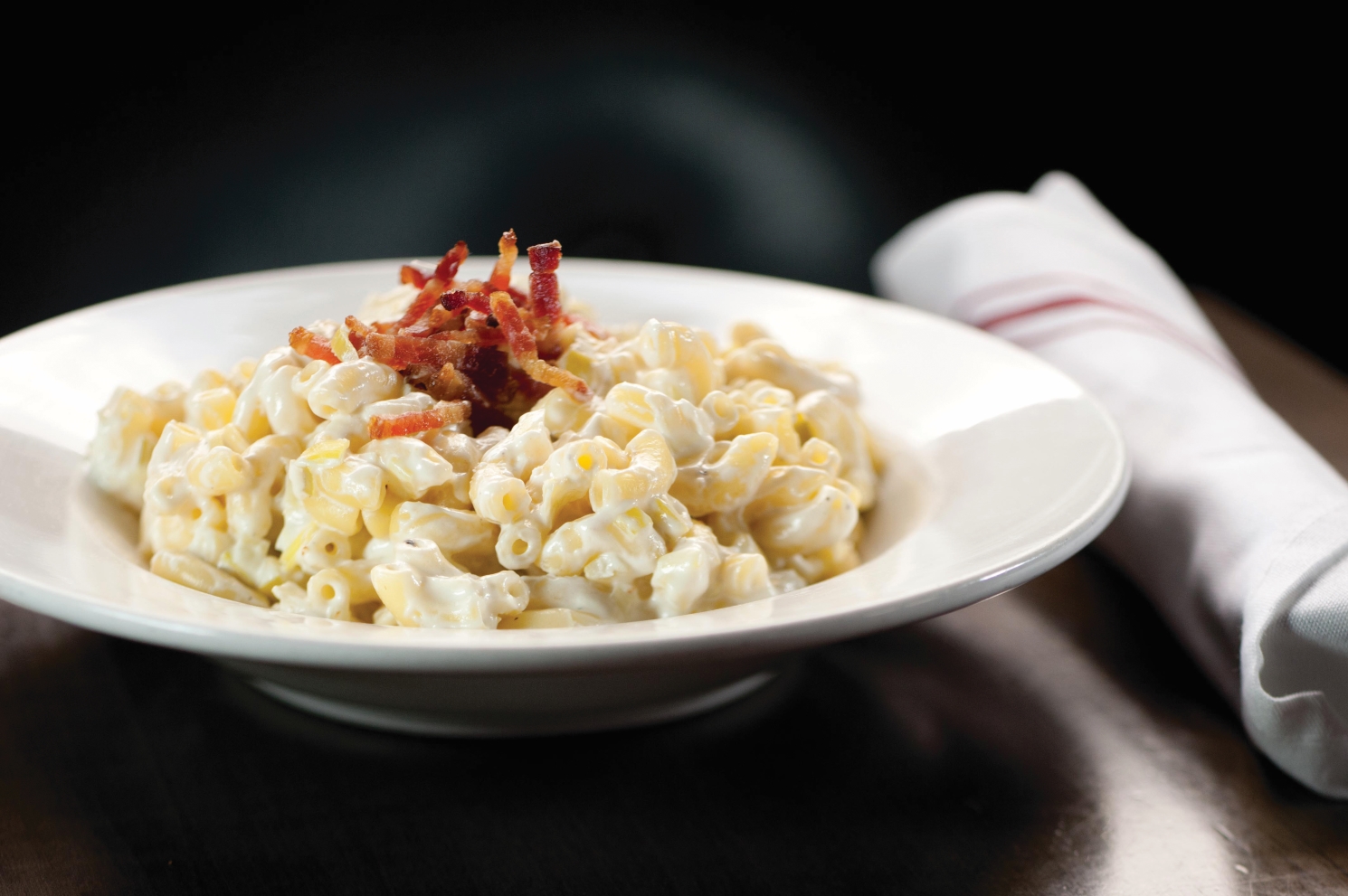 Macaroni and cheese topped with crumbled bacon