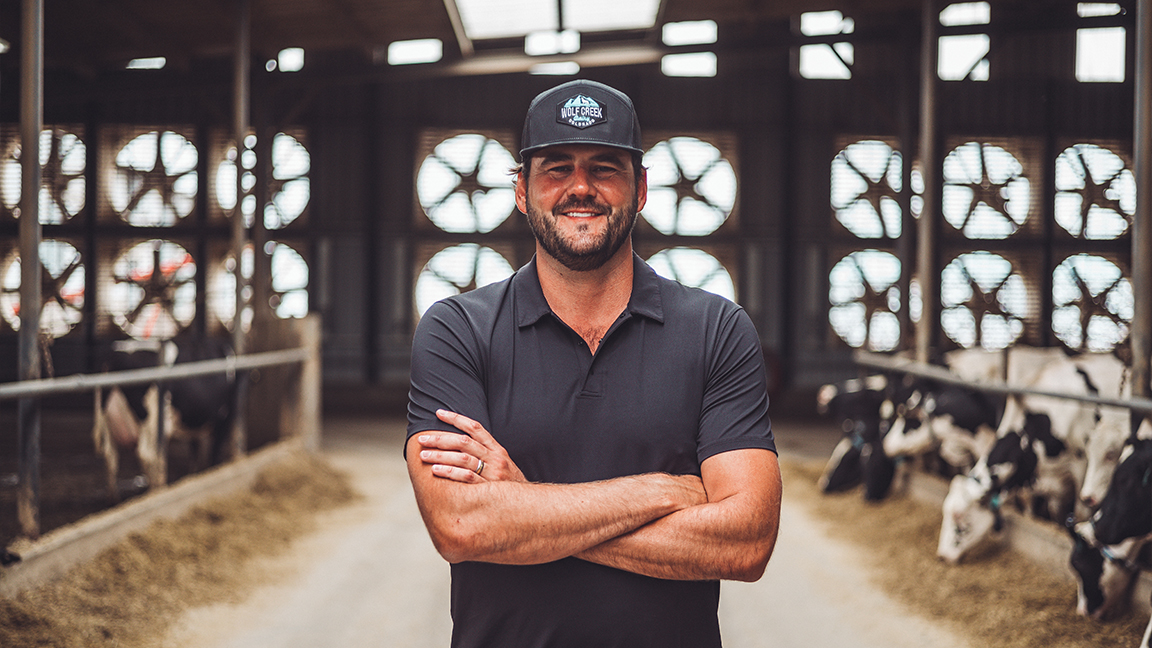 Farmer in Barn with cows.