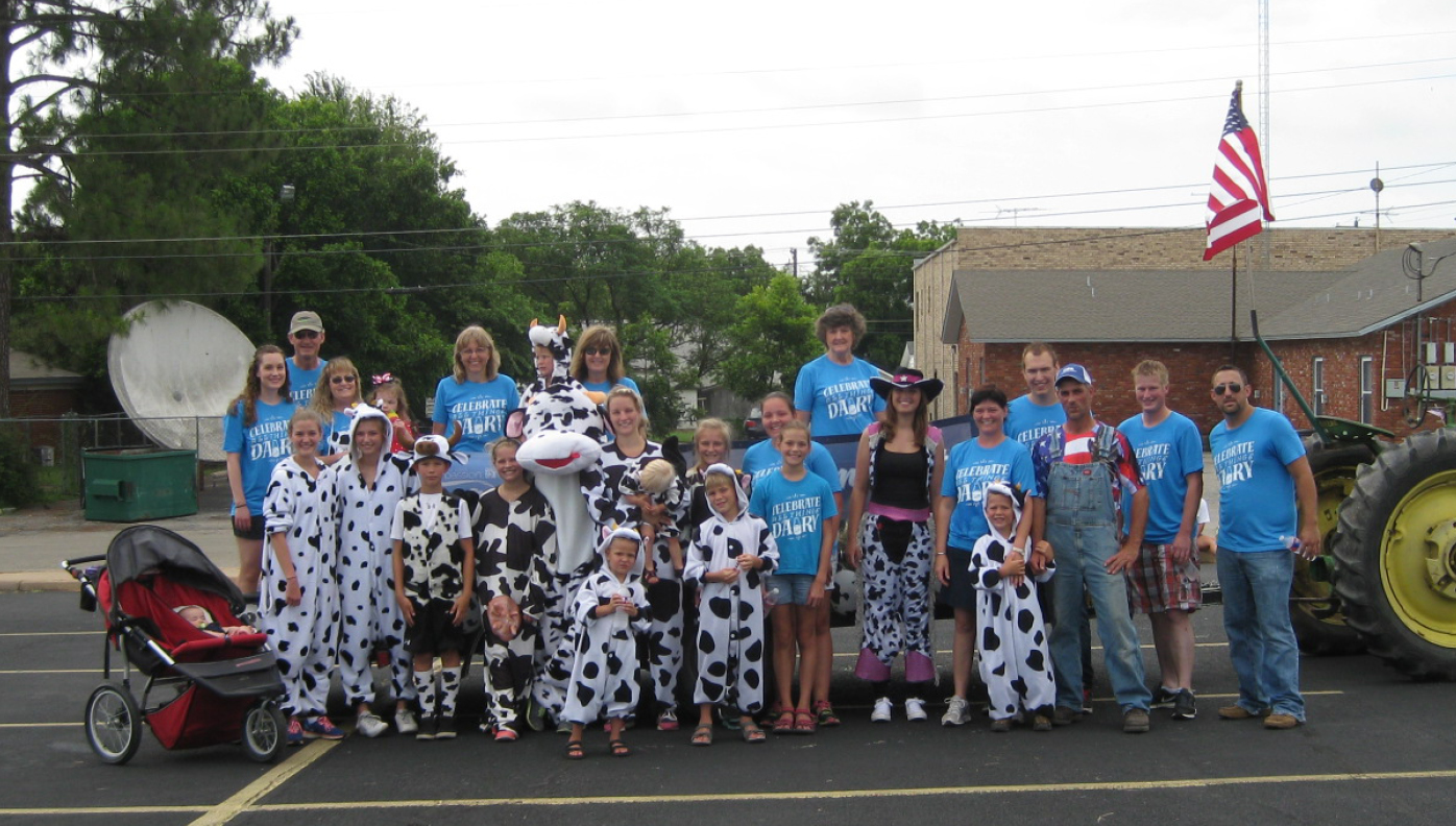 group of people with a parade float that is dairy themed