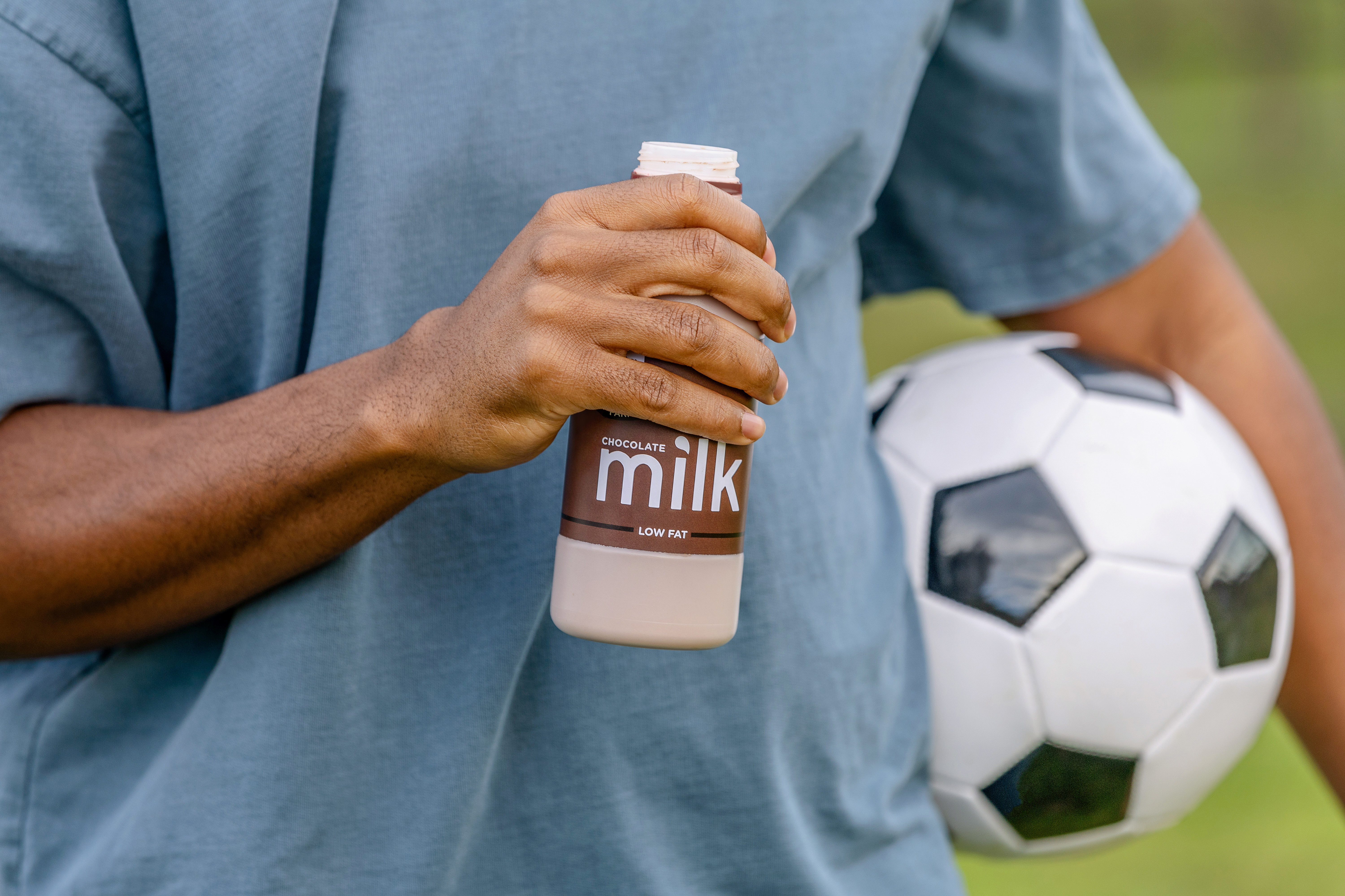 Athlete holding soccer ball and chocolate milk