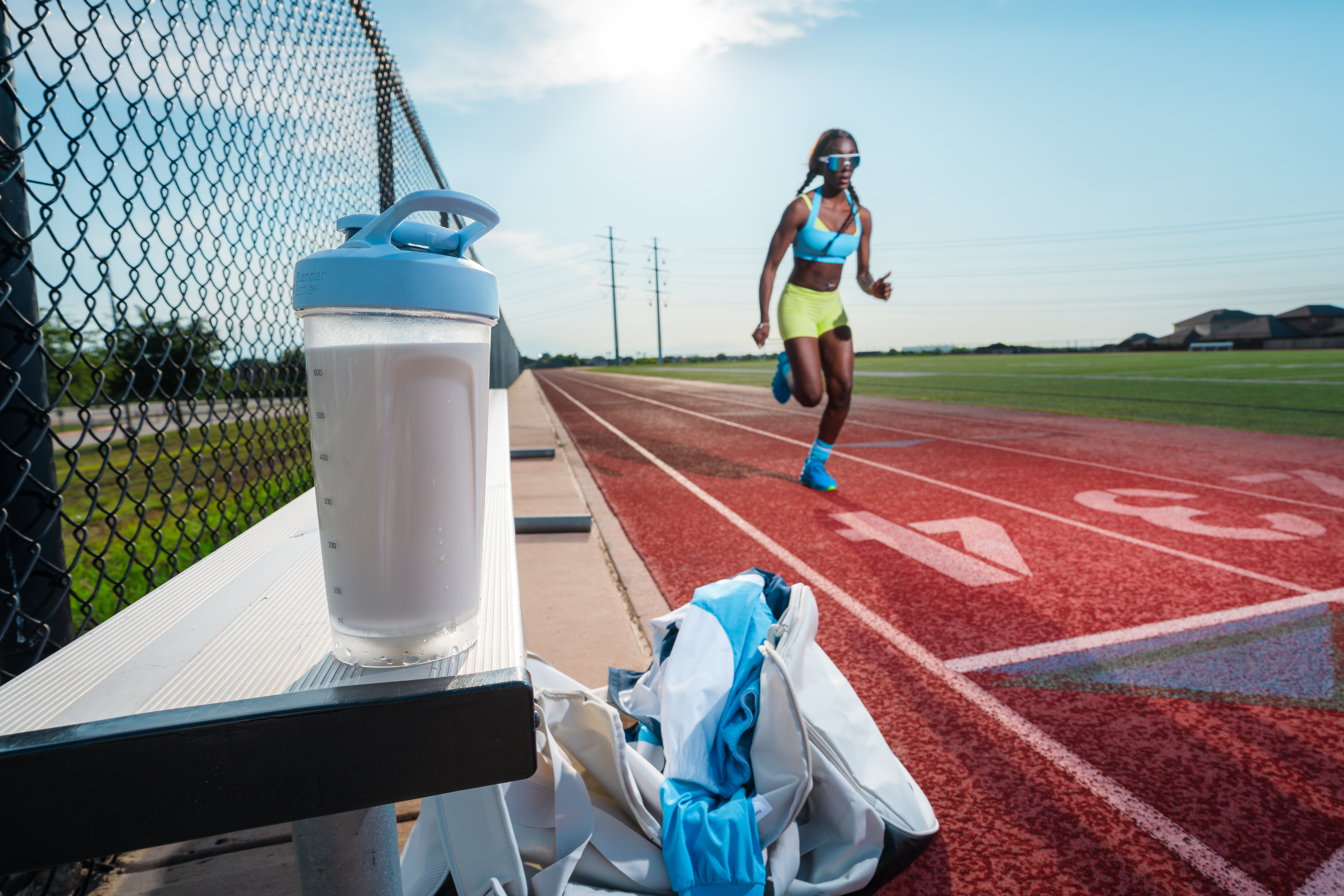 Young woman athlete runs on a track