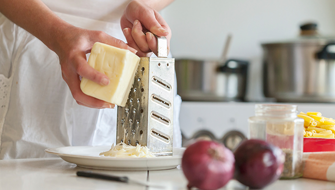 grating a piece of white cheese