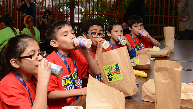 kids drinking milk with sack lunches