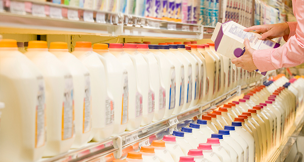 person looking at the nutrition facts on a jug of milk