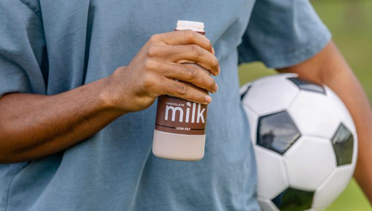 Athlete holding soccer ball and chocolate milk