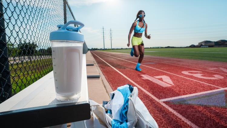 Young woman athlete runs on a track