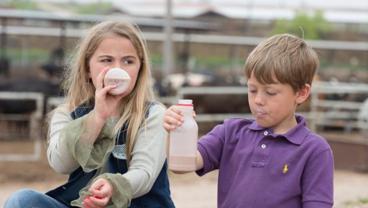 two kids drinking milk