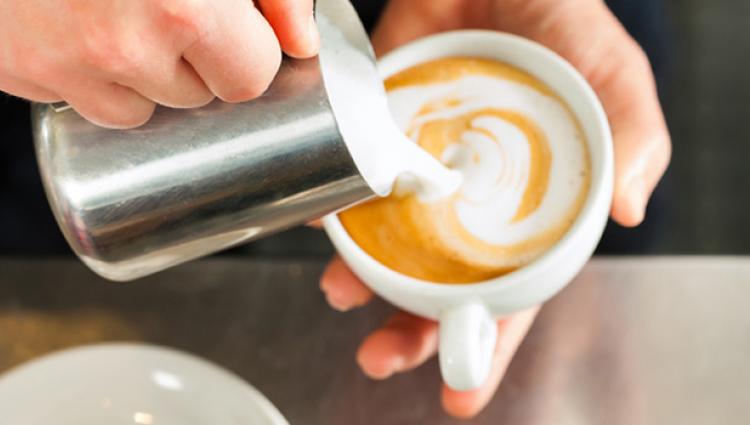 person pouring a latte