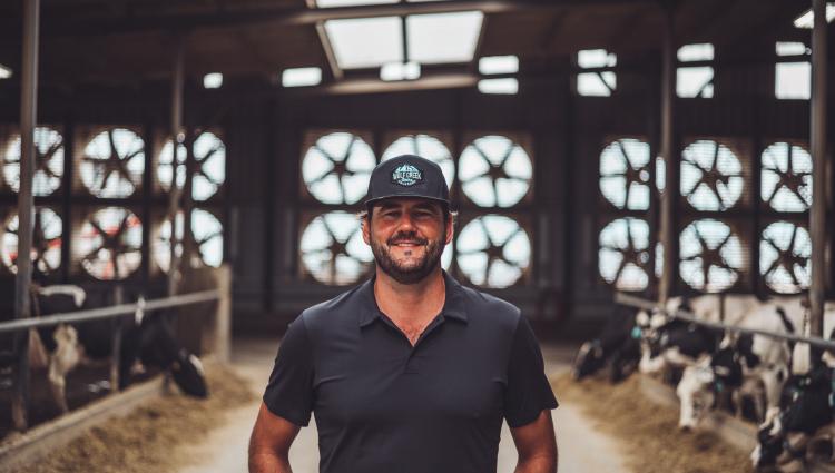 Dairy Farmer standing in front of barn fans.