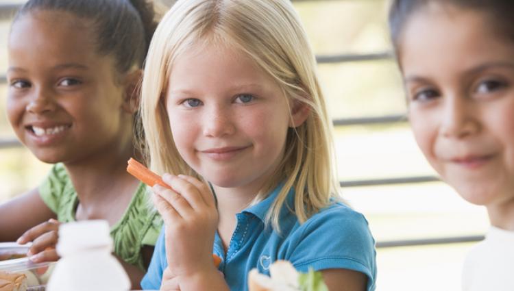 young kids drinking milk and eating vegetables