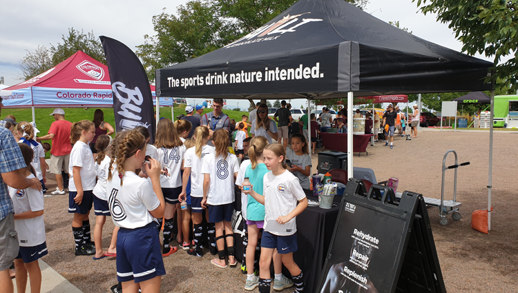 group of young athletes getting chocolate milk at Dairy MAX's Built tent